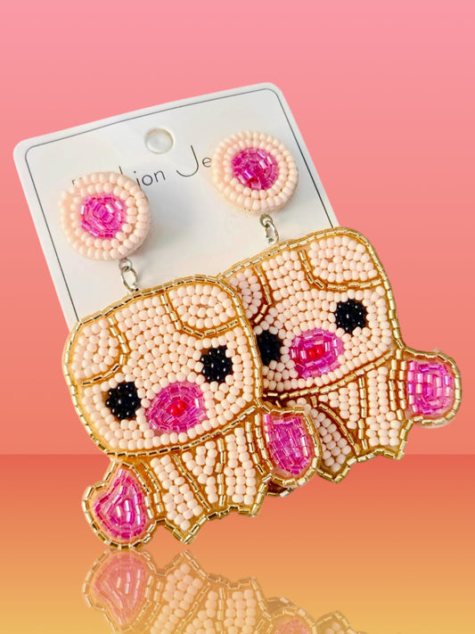 Aretes de cerdito con cuentas de chaquira hechos a mano.